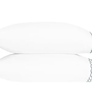 Two white pillows stacked on top of each other, featuring a decorative blue scalloped trim along the edges. Featuring Classic Chain Scallop bedding by Matouk. Available at Linen Society.