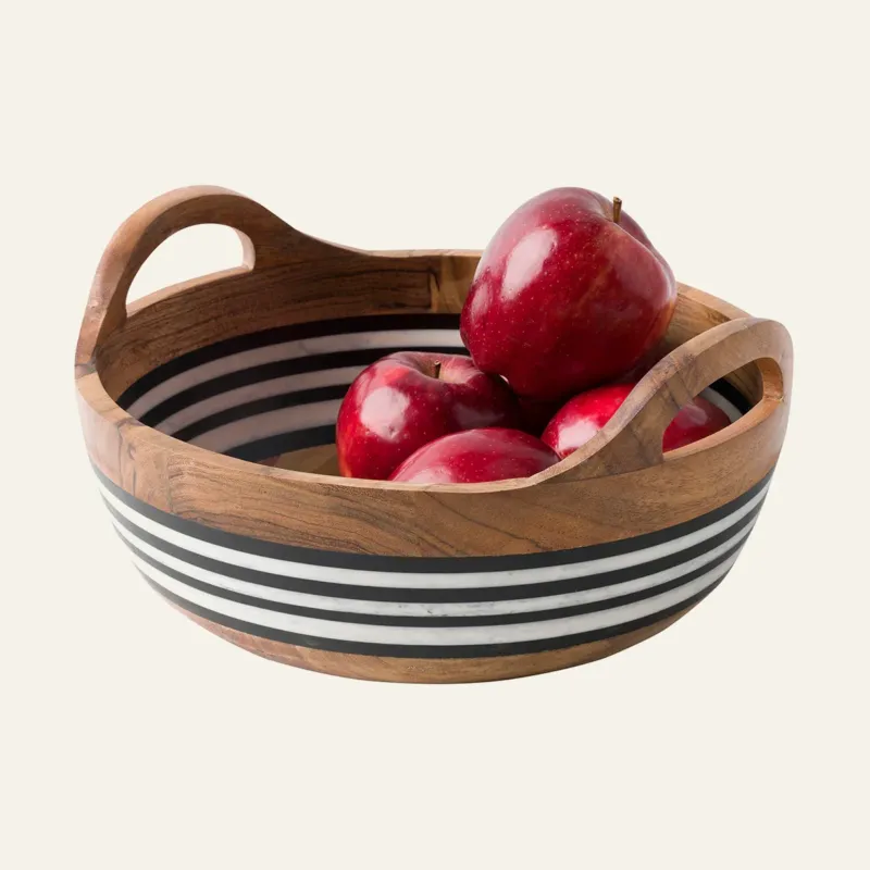 Juliska Stonewood Stripe round handled bowl in acacia wood with black and white stripes, filled with red apples.