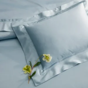 Matouk Nocturne flat sheet in powder blue sateen with matching pillow sham and floral stems.