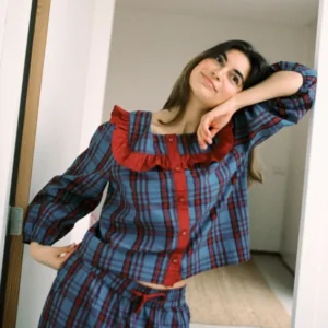 Woman in a relaxed pose wearing TBCo Cropped Cotton Pyjamas in Navy Tartan featuring a ruffle collar and breathable cotton fabric